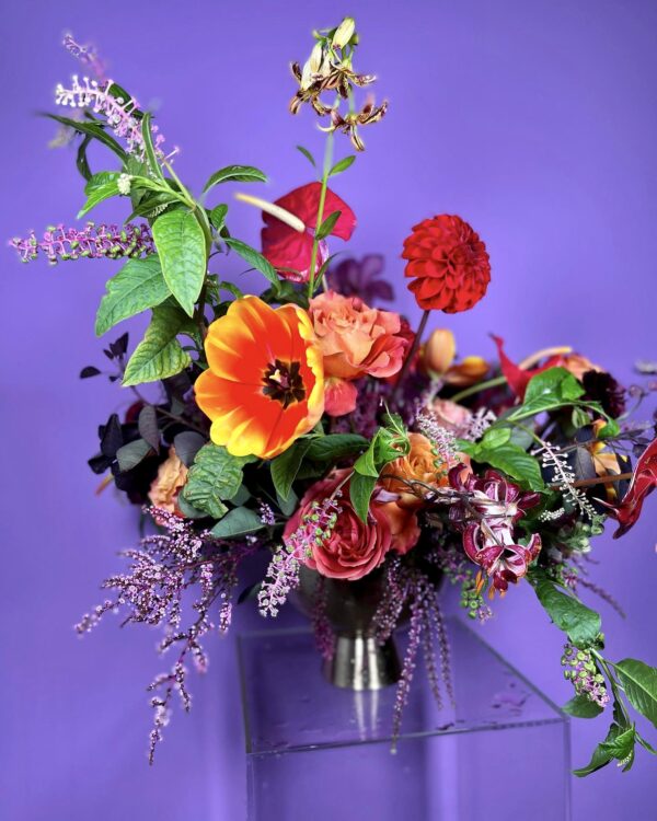 Flower arrangement with orange, red, purple, and green blooms
