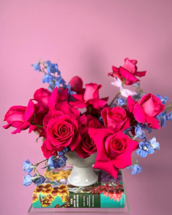 Flower arrangement with magenta roses and blue delphinium