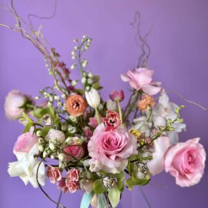 Flower arrangement with pink and white roses and green orchids