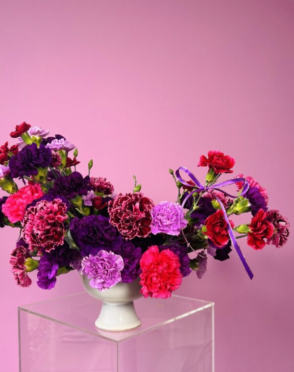 Flower arrangement with purple and red carnations