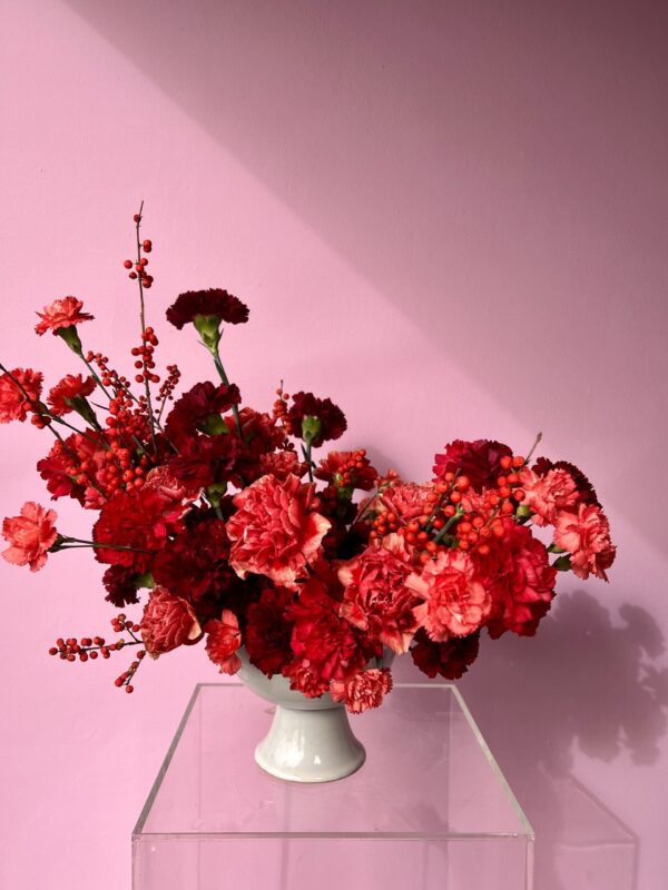 Flower arrangement with red carnations and berries
