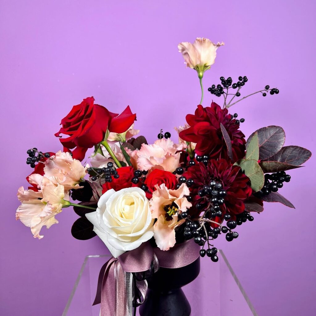 Flower arrangement with white and red roses and berries